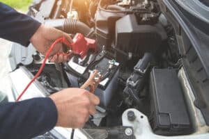 Mechanic hand charging car with electricity trough jumper cables